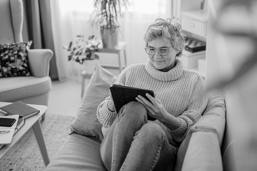 Woman using tablet at home representing clinical technology aligned with site and patient needs in clinical trials