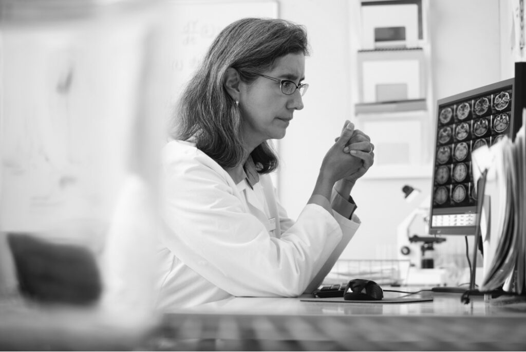 Clinician reviewing neurological medical images on a computer for rare disease eCOA research
